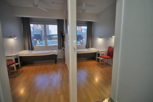 a room with two beds and a room with two windows at Hotelli Kerava in Kerava