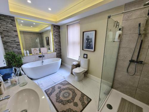 uma casa de banho com uma banheira, um lavatório e um chuveiro em The Snug Lytham em Lytham St Annes