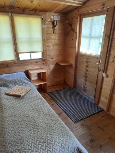 Bungalo في يورمالا: غرفة نوم بسرير في كابينة خشبية