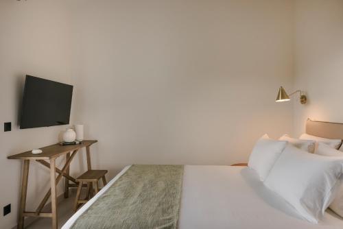 a bedroom with a bed and a desk with a television at Rodi Studios in Karavadhos