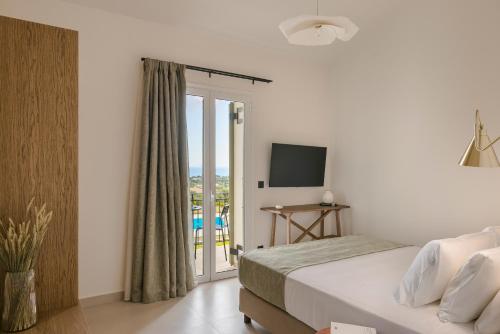 a bedroom with a bed and a sliding glass door at Rodi Studios in Karavadhos