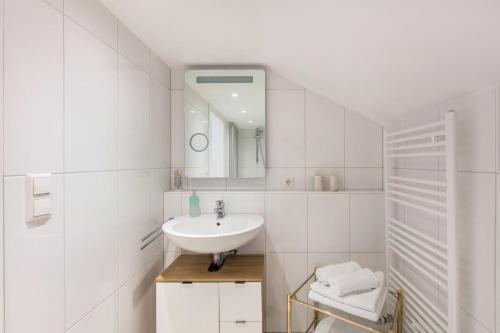 bagno bianco con lavandino e specchio di Ferienwohnung Haus Oehlberg a Todtmoos
