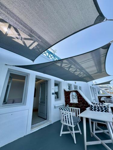 a balcony with a table and chairs on a yacht at Ilioperato Hotel in Imerovigli