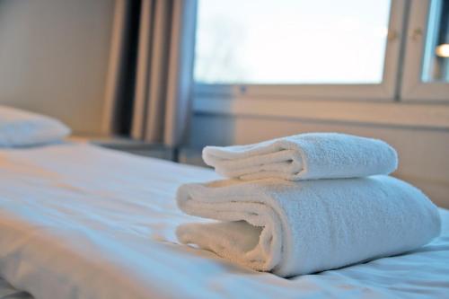a pile of towels sitting on top of a bed at Hotelli Kerava in Kerava