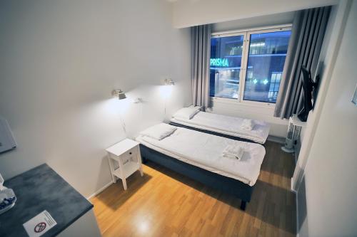 a small room with two beds and a window at Hotelli Kerava in Kerava