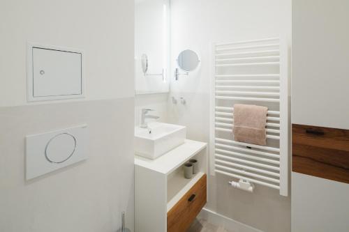 a white bathroom with a sink and a mirror at Nordstrandperle Ap H9 in Norderney