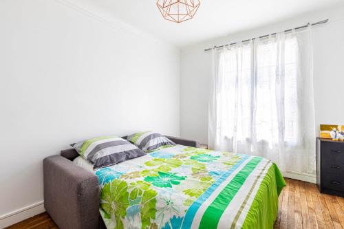 une chambre avec un lit avec une courtepointe colorée dessus dans l'établissement GuestReady - Cosy Studio Proche du Métro, à Paris