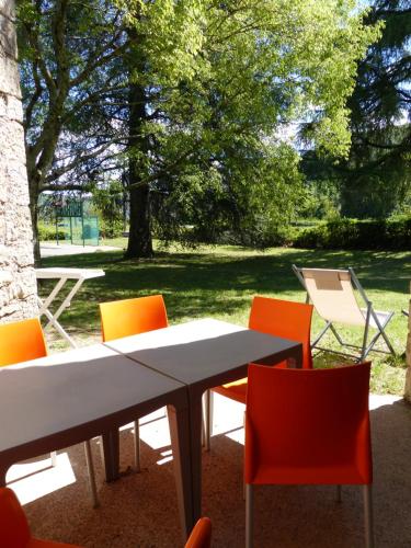 a table and chairs with a picnic table in a park at Terres de France - Le Domaine des Vans in Chambonas
