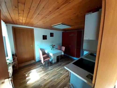 a room with a table and a kitchen with wooden ceilings at Zu den Ravensbergen in Potsdam
