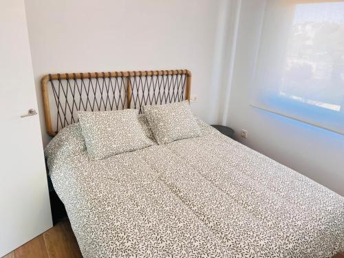 a bed with two pillows on it in a bedroom at Sevenhouses Pilar de La Horadada in Pilar de la Horadada