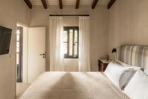 Schlafzimmer mit einem Bett und einem Fenster in der Unterkunft Koutouloufari Village Holiday Club in Hersonissos