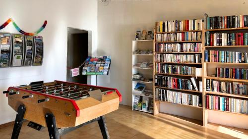 une pièce avec un baby-foot et des étagères de livres dans l'établissement Camping Naturiste Tikayan Petit Arlane, à Valensole