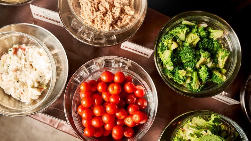 a table with bowls of tomatoes broccoli and other foods at Daiwa Roynet Hotel Sendai Ichibancho PREMIER in Sendai