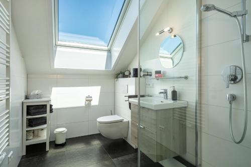 uma casa de banho com um WC, um lavatório e uma clarabóia em Haus Sohl 2 em Friedrichshafen