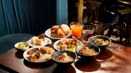 a table topped with plates of food and bowls of food at Daiwa Roynet Hotel Sendai Ichibancho PREMIER in Sendai