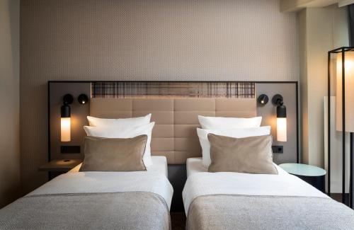 two beds sitting next to each other in a room at Leonardo Royal Hotel Frankfurt in Frankfurt/Main