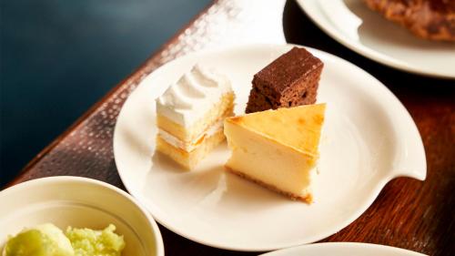 three pieces of cake on a plate on a table at Daiwa Roynet Hotel Sendai Ichibancho PREMIER in Sendai