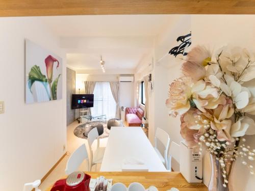a dining room with a table and a vase of flowers at Shinjuku Area, Hatsudai 7min walk, PS5 , Switch , Free Wi-Fi , PocketWi-Fi in Tokyo
