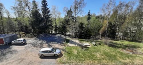 dos coches estacionados en un estacionamiento con árboles en Furnished 2 room appartment in Vasa en Vaasa