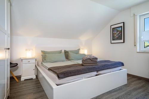 a white bed in a room with two lamps at Haus Sohl 1 in Friedrichshafen