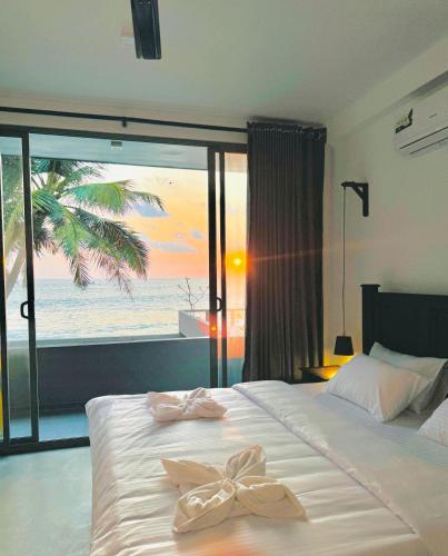 a bedroom with a bed with a view of the ocean at Villa Sea Queen in Ambalangoda