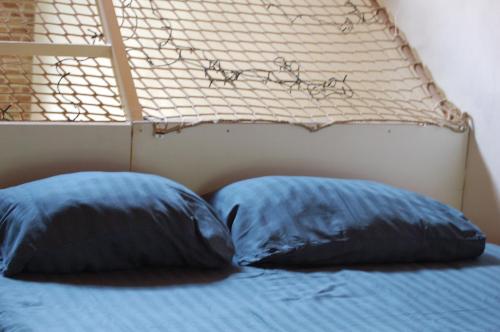 2 almohadas sentadas encima de una cama en Galerie Petit Delfshaven en Róterdam