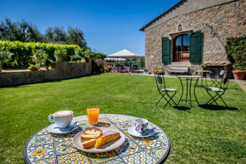 una mesa con un plato de pastas y tazas de café en La Fornace Di Racciano, en San Gimignano
