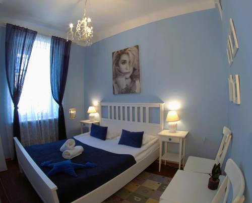 華沙的住宿－Chmielna Guest House，一间卧室配有一张大床,配有蓝色的床单和蓝色的枕头。