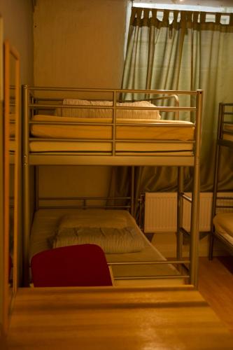 2 literas en una habitación con silla roja en Gamla stans Hostel, en Estocolmo