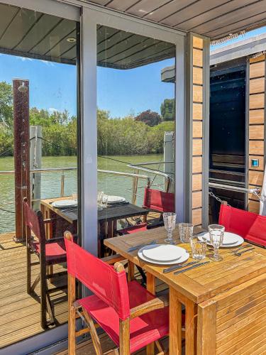 une terrasse avec une table et des chaises sur un bateau dans l'établissement Séjour Unique sur un Bateau 