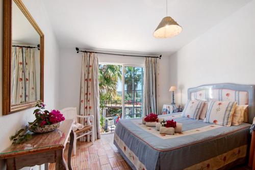 a bedroom with a bed and a table and a window at Country House Quinta da Ilda in Loulé