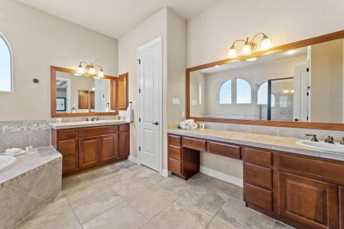 a bathroom with two sinks and a large mirror at 3 Kings with Theater, GameRoom and BBQ just 7 mins from Marina in Austin