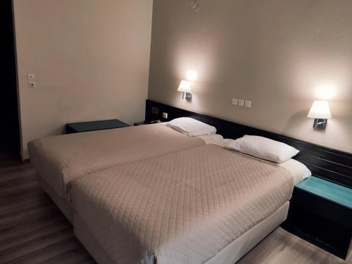 a bedroom with a large bed with two pillows at Plaza Hotel in Alexandroupoli