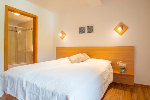 a bedroom with a large white bed and a shower at Exclusive Panorama Spa Suiten DAS SCHILLER in Bad Gastein