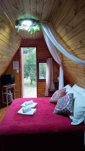 a bedroom with a large bed with a red blanket at Pousada Bosque do Visconde in Visconde De Maua