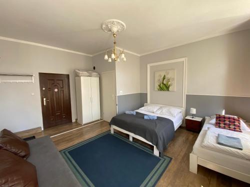 a bedroom with two beds and a couch at Hacienda in Sopot