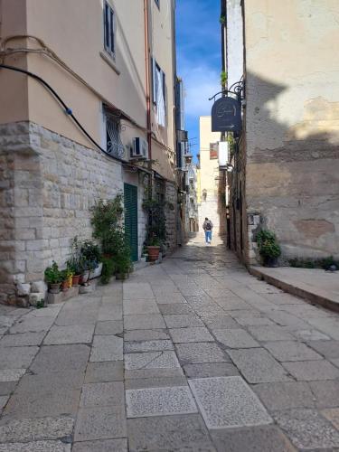 an alley with a person walking down the street at Maison Divino in Trani