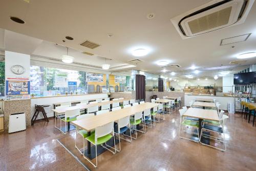 una sala da pranzo con tavoli e sedie in un ristorante di Hotel 1-2-3 Kurashiki a Kurashiki