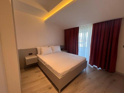 a bedroom with a bed and a window with red curtains at Ulu Panorama Residence in Alanya