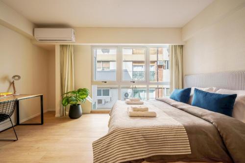 a bedroom with a large bed with two towels on it at Fliphaus Be Libertador - Lux Loft 12-22 in Buenos Aires