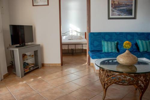 a living room with a blue couch and a table at Urban Beach - Casa Amarela in Carvoeiro