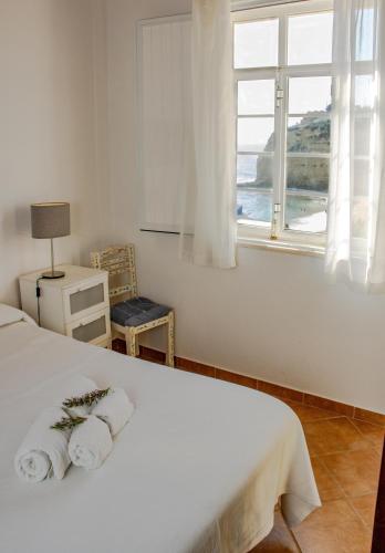 a bedroom with a white bed and a window at Casa Amarela by Urban Beach Rentals in Carvoeiro