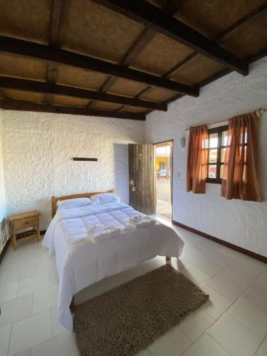 a bedroom with a large white bed and a window at Posada TyM in Trinidad