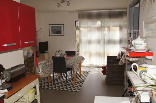 a kitchen with a table and a dining room at Studio RDC Terrasse Repos en Cote d'Armor in Perros-Guirec