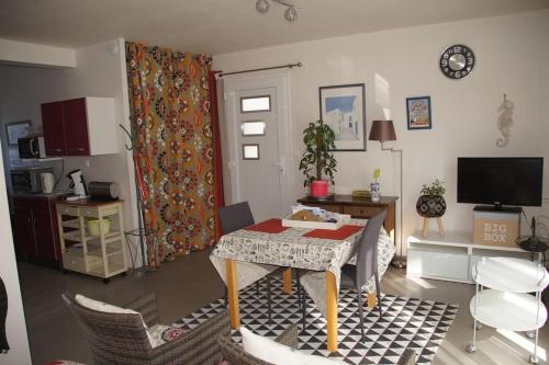 a living room with a table and some chairs at Studio RDC Terrasse Repos en Cote d'Armor in Perros-Guirec
