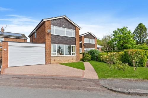 a brick house with a white garage at Woodvale Gardens in Wylam