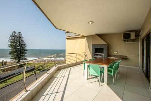balcone con tavolo, sedie e vista sull'oceano di Saints View Resort Unit 22 a Uvongo Beach