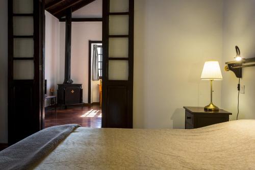 a bedroom with a bed and a lamp on a table at Casa Rural La Escalerilla in Teror