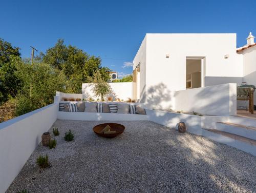 a white house with a couch and a table at Casa Bartolomeu in Castro Marim