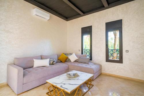 a living room with a couch and a table at Villa Riad Mamouni - piscine privée et jacuzzi in Marrakech